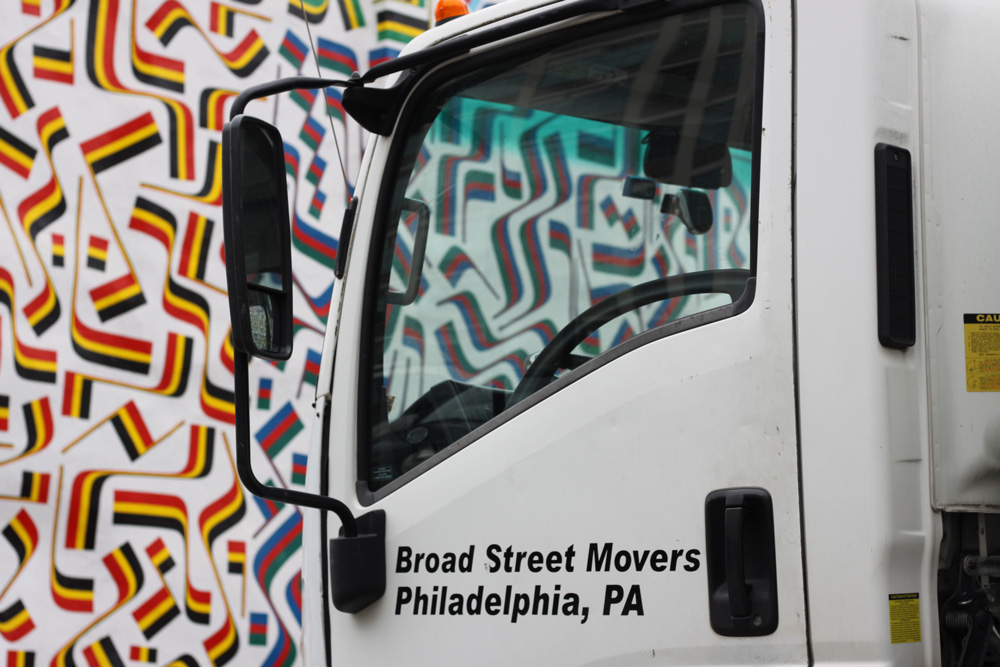 Artistic close-up view of Broad Street Movers truck cab against vibrant patterned backdrop